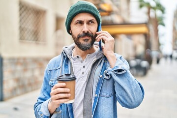 Canvas Print - Young bald man talking on smartphone drinking coffee at street