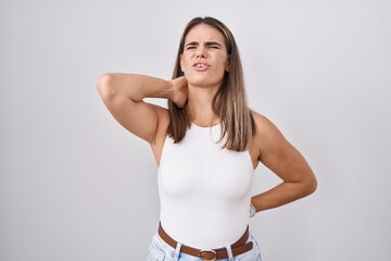 Poster - Hispanic young woman standing over white background suffering of neck ache injury, touching neck with hand, muscular pain