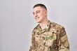 © Krakenimages.com - Young man wearing camouflage army uniform looking away to side with smile on face, natural expression. laughing confident.