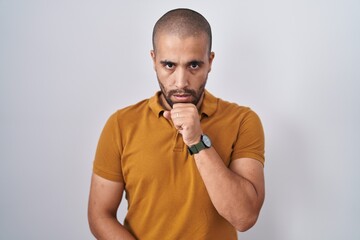 Poster - Hispanic man with beard standing over white background feeling unwell and coughing as symptom for cold or bronchitis. health care concept.