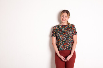 a woman in fashionable clothes poses on a white background