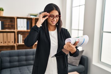 Canvas Print - Young latin woman psychologist holding clipboard standing at clinic