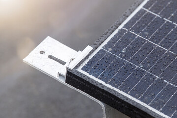 Bracket for mounting solar panels. Mounting a solar panel close-up on the roof of a residential building, water drops after rain, green energy production.