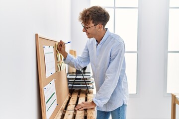 Sticker - Young caucasian man writing on corkboard working at office