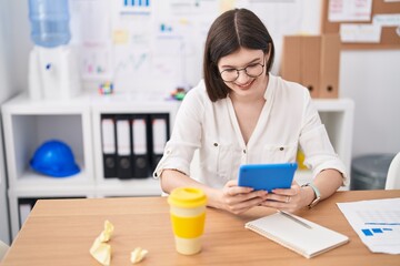 Poster - Young caucasian woman business worker using touchpad at office