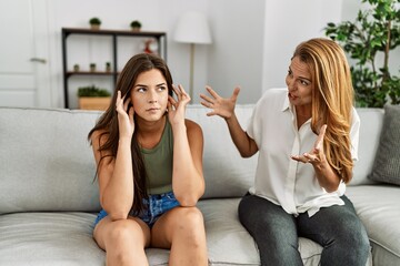 Poster - Mother and daughter unhappy arguing sitting on sofa at home