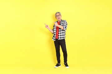 Wall Mural - The 40s adult Asian man with casual dressed standing on the yellow background.