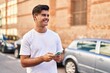 © Krakenimages.com - Young hispanic man smiling confident using smartphone at street