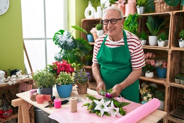 Sticker - Middle age grey-haired man florist make bouquet of flowers at flower shop