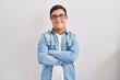 © Krakenimages.com - Young hispanic man with down syndrome wearing casual denim jacket over white background happy face smiling with crossed arms looking at the camera. positive person.