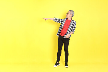 Wall Mural - The 40s adult Asian man with casual dressed standing on the yellow background.