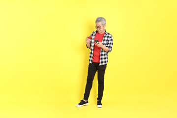 Wall Mural - The 40s adult Asian man with casual dressed standing on the yellow background.