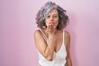 © Krakenimages.com - Middle age woman with grey hair standing over pink background looking at the camera blowing a kiss with hand on air being lovely and sexy. love expression.