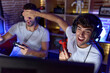 © Krakenimages.com - Two hispanic men streamers playing video game covering eyes cheating at gaming room