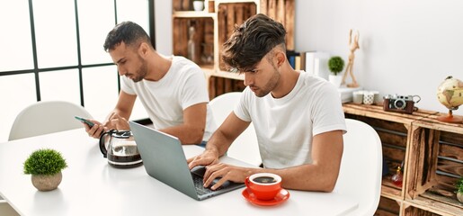 Sticker - Two hispanic men couple using smartphone and laptop at home