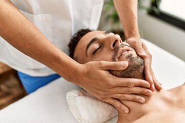 Canvas Print - Two hispanic men therapist and patient having facial massage at beauty center