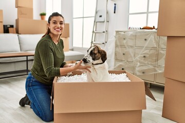 Wall Mural - Young woman smiling confident playing with dog at home