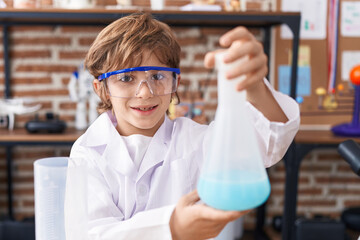 Sticker - Adorable caucasian boy student holding test tube at classroom