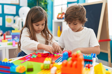 Sticker - Brother and sister playing with construction blocks sitting on table at kindergarten