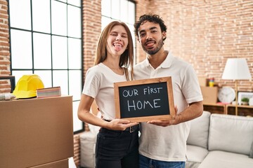 Sticker - Young two people holding blackboard with first home text sticking tongue out happy with funny expression.