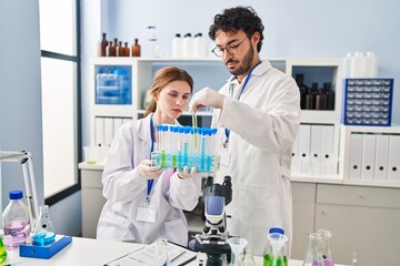 Sticker - Man and woman scientist partners holding test tubes at laboratory