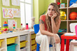 © Krakenimages.com - Young blonde woman teacher sitting on chair with serious expression at kindergarten