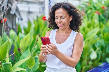 Sticker - Middle age woman using smartphone with serious expression at park