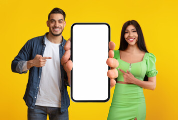 Poster - Special Offer. Smiling Middle Eastern Couple Demonstrating Blank Smartphone With White Screen