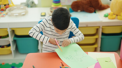 Sticker - Adorable hispanic boy student cutting paper at kindergarten