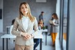 © Dragana Gordic - Shot of a confident young businesswoman standing in a modern office. Portrait of a businesswoman standing in the office. One Happy Pretty Business Woman Standing in office