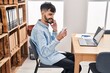 © Krakenimages.com - Young hispanic man business worker talking on smartphone reading notebook at office