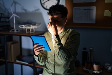 Wall Mural - Non binary person using touchpad device at night tired rubbing nose and eyes feeling fatigue and headache. stress and frustration concept.