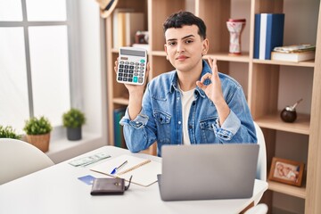 Canvas Print - Non binary person calculating money savings doing ok sign with fingers, smiling friendly gesturing excellent symbol