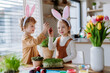 © Halfpoint - Little kids with bunny ears celebrating easter, playing easter game with egg.