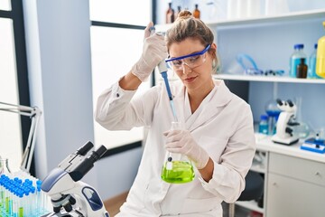 Canvas Print - Young blonde woman wearing scientist uniform using pipette at laboratory