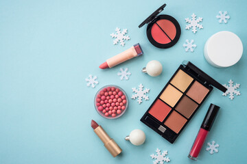 Poster - Make up products and christmas decorations on blue background. Holiday shopping. Flat lay image with copy space.