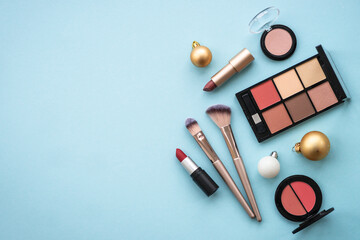 Poster - Make up products and winter decorations on blue background. Winter cosmetic. Flat lay image with copy space.