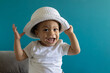 © Anna Berkut/Stocksy - happy smiling one year old baby portrait in hat