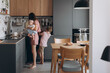 © Alina Hvostikova/Stocksy - Mother with baby in kitchen at home