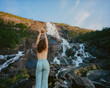 Woman near waterfall in mountains 