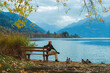 © Anna Tsukanova/Stocksy - Woman sitting on the bench near the lake in Austrian Alps