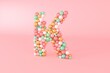 © Bruno Tornielli/Stocksy - Letter K made of glass balls, pastel pearls, crystal jewels and gold.