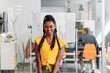 © VICTOR TORRES/Stocksy - Happy black employee in yellow wear in office