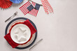 Patriotic table setting with USA flag and decoration on white background. Independence Day. Picnic BBQ and Happy Memorial Day 4th of july. View from above. Copy space,