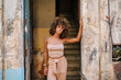 © Daniel Gonzalez/Stocksy - Confident Cuban woman in old building doorway