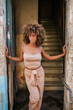 © Daniel Gonzalez/Stocksy - Cuban woman in entrance of old building on street