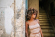 © Daniel Gonzalez/Stocksy - Stylish Cuban female leaning on wall near steps