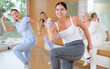© JackF - Group of energetic young mature female dancers dancing with knee lift during training together in dance hall
