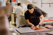 © VICTOR TORRES/Stocksy - Young cook arranging meat on tray