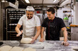 © VICTOR TORRES/Stocksy - Baker teaching colleague to make dough